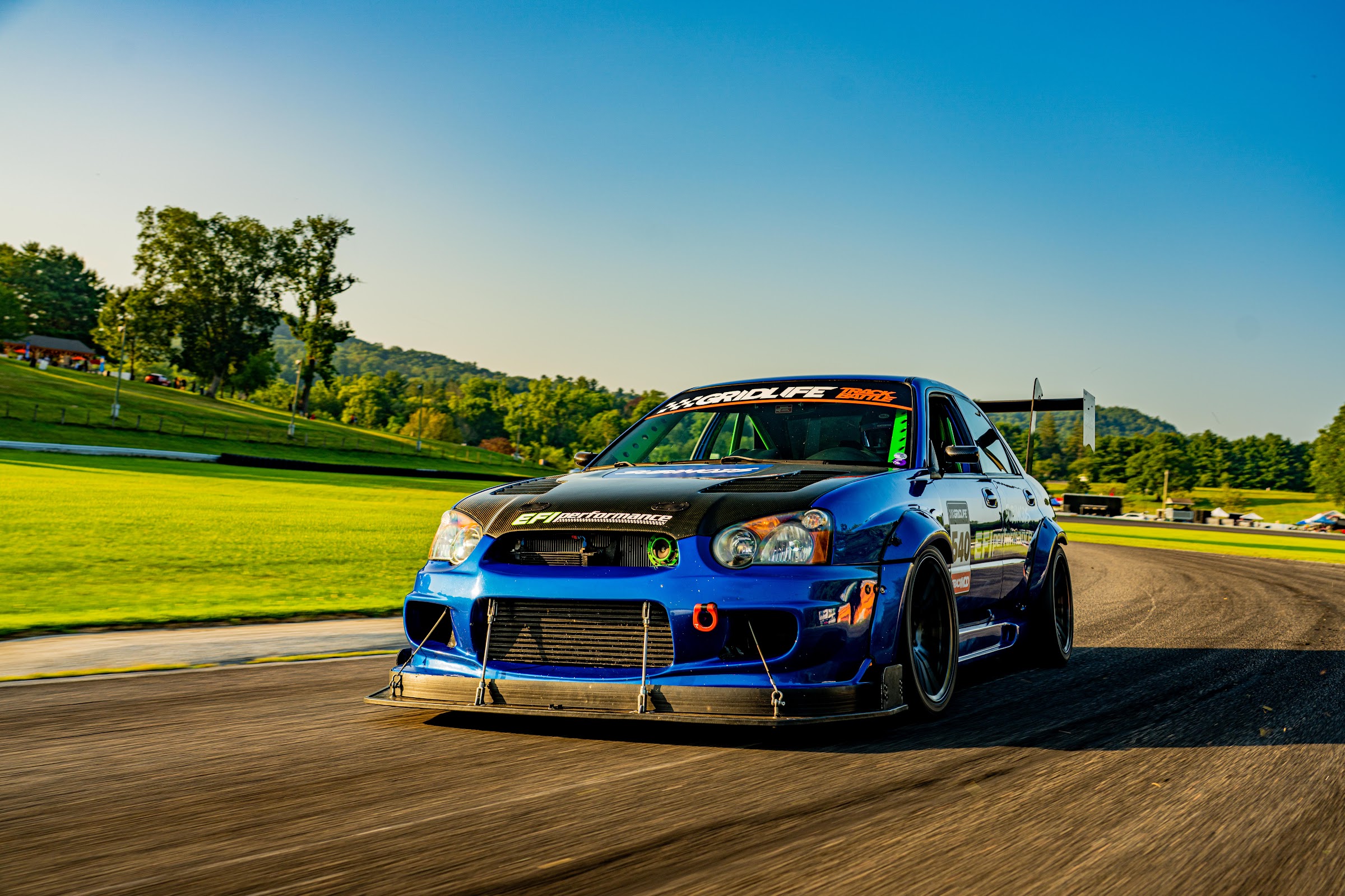 Blue widebody STI rolling shot head-on