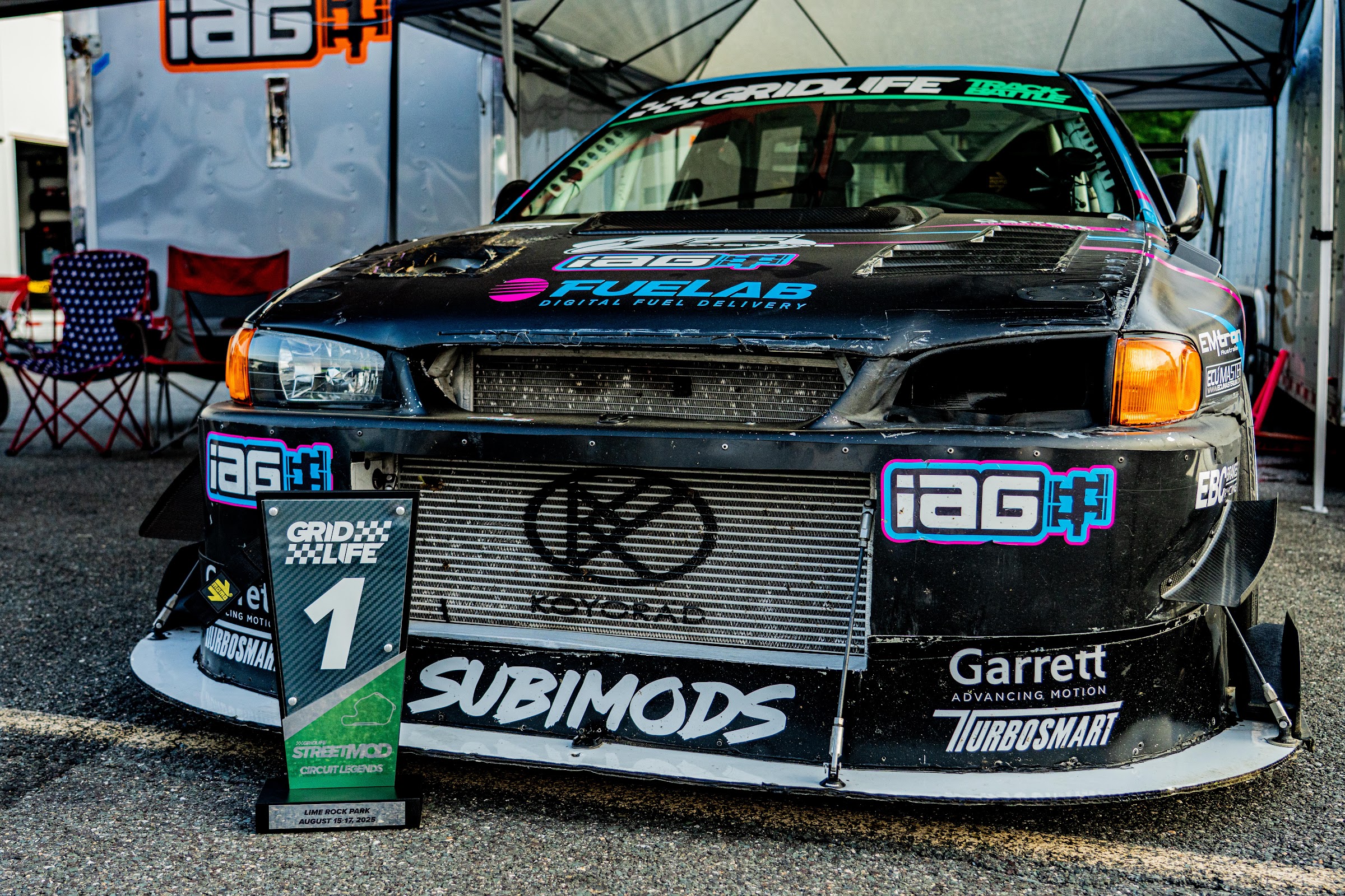 Sponsor-liveried competition car staged in the paddock