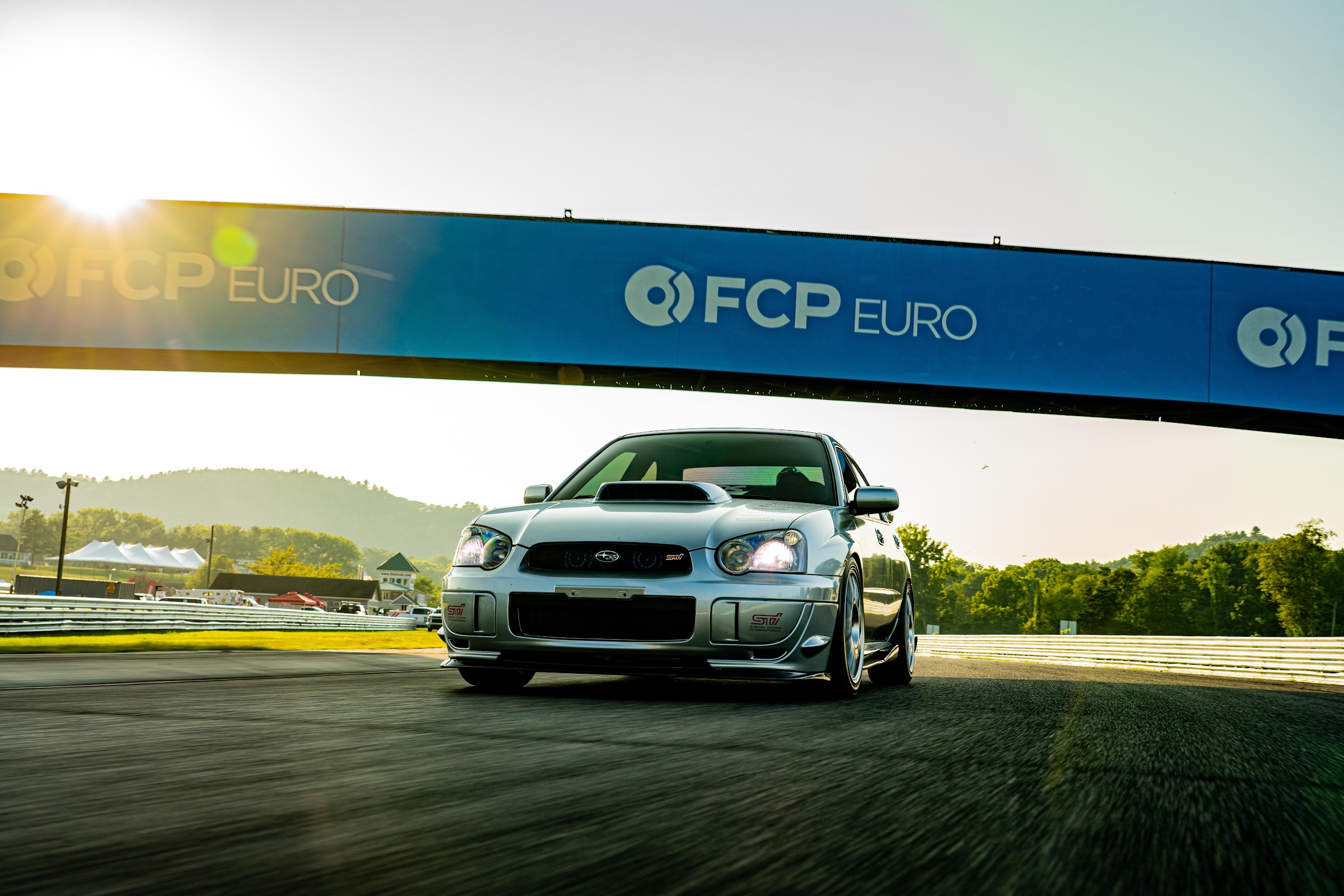 Silver Subaru rolling shot past FCP Euro signage